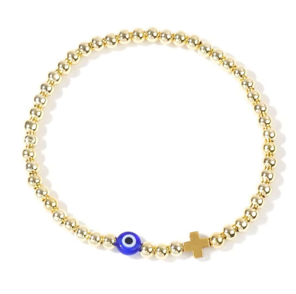 Gold beaded bracelet with a blue evil eye charm and a gold cross on a white background