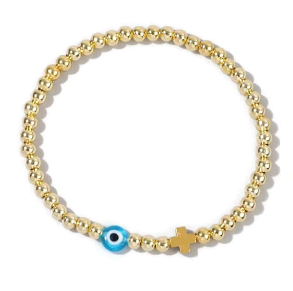 Gold beaded bracelet with a blue evil eye charm and a gold cross on a white background