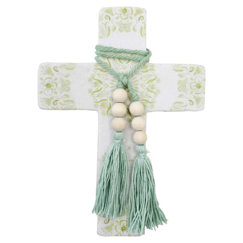 Decorative cross with floral pattern, beads, and tassels on a white background